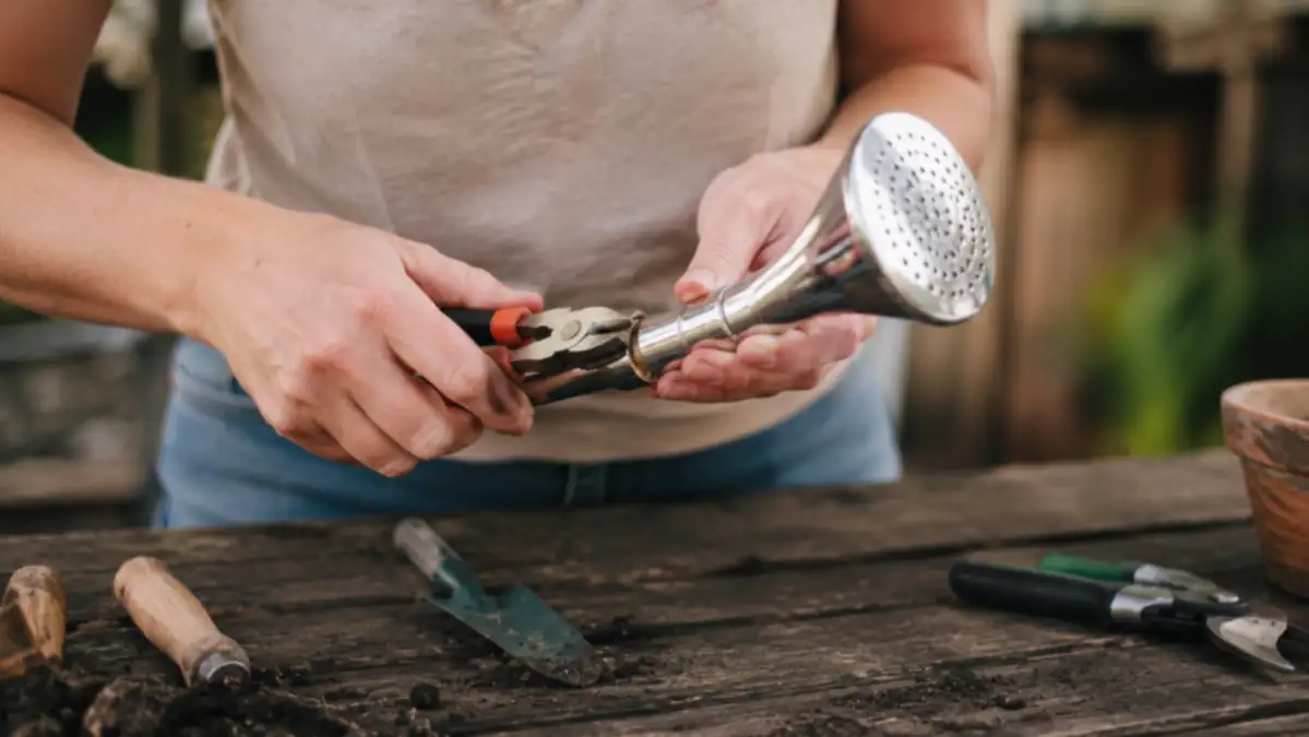 Close-up of the Green Mount stainless shower head being tightened with pliers where it had arrived slightly loose